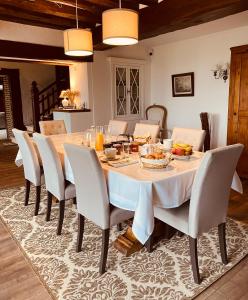 uma sala de jantar com mesa e cadeiras em Le Manoir de Sainte-Aulde 