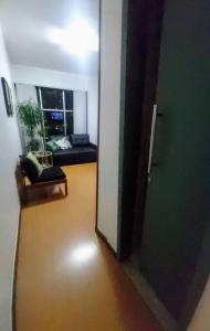 a hallway with a room with a couch and a window at Flat Perto de Tudo na Savassi in Belo Horizonte