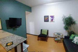 a living room with a couch and a tv at Flat Perto de Tudo na Savassi in Belo Horizonte