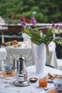 stół z wazą fioletowych kwiatów i świecą w obiekcie Artemide Relais w mieście Montebelluna