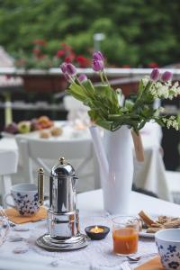 a table with a vase of purple flowers and a candle at Artemide Relais in Montebelluna