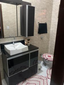 a bathroom with a sink and a toilet at Casa Grande in Imbituba +12 photos