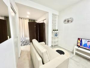 馬德里的住宿－Metro Avenida de América 01，客厅配有白色沙发和电视