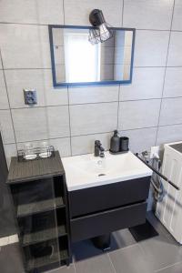 bagno con lavandino e specchio di Apartma Ella a Lovrenc na Pohorju