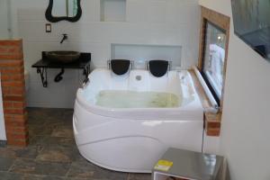 a white bath tub in a bathroom with a sink at Villa Milú Refugio boutique in Guaduas +58 photos