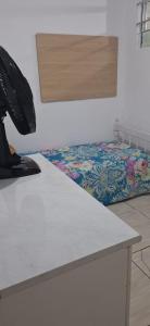 een tafel in een kamer met een bed in de hoek bij KitnetdaNathy. in Itajaí