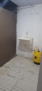 een badkamer met een toilet en een gele emmer bij KitnetdaNathy. in Itajaí
