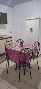 een tafel met twee stoelen en een tafelkleed erop bij KitnetdaNathy. in Itajaí
