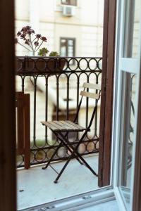 einen Stuhl auf einem Balkon mit einem Fenster in der Unterkunft Artisan Maison in Palermo