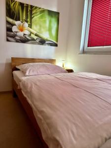 1 dormitorio con 1 cama y una pintura en la pared en Gäste-Appartement-Kirsammer, en Eningen unter Achalm
