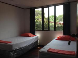 EL-CACIQUE-guesthouse-since-2003 في Santiago Este: سريرين في غرفة مع نافذة