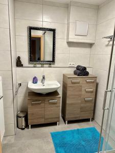 ein Bad mit einem Waschbecken und einem Spiegel in der Unterkunft Gäste-Appartement-Kirsammer in Eningen unter Achalm