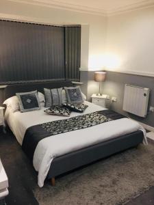 a bedroom with a large bed with pillows on it at Arden House NEC Birmingham in Bickenhill