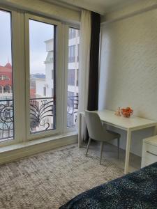 een hotelkamer met een bureau en een raam bij Bernardazzi residence in Chişinău