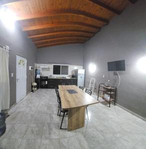 Habitación grande con mesa de madera y sillas. en La Blanqueada en Mina Clavero