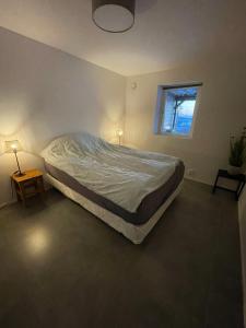 a large bed in a bedroom with a window at Ny lägenhet på markplan med havsutsikt in Strömstad