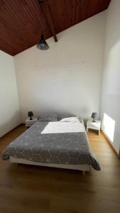Résidence le Télémaque في كونكا: غرفة نوم مع سرير وطاولتين النهاية