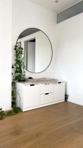 a white bathroom with a mirror and a white dresser at Helle Wohnung in Top Lage! in Linz