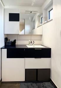 a kitchen with white and black cabinets and a sink at Helle Wohnung in Top Lage! in Linz