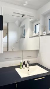 a white bathroom with a sink and a mirror at Helle Wohnung in Top Lage! in Linz