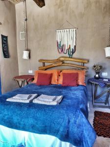 Un dormitorio con una cama azul con toallas. en El Cerrito en Maimará