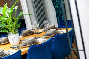 a long wooden table with blue chairs and glasses at 31 Bailgate Lincoln in Lincolnshire