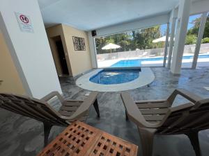 a room with chairs and a swimming pool at Altos del Golf - Fito in Punta del Este