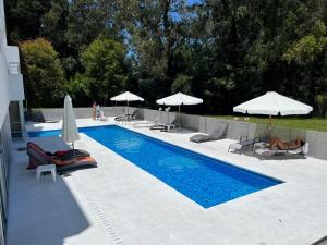 a swimming pool with chairs and umbrellas next to at Altos del Golf - Fito in Punta del Este