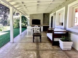 een veranda met een bank en een tafel op een huis bij Casa de 6 ambientes a 2 cuadras de la playa brava in Punta del Este