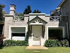 una casa con una puerta blanca y dos garajes en Casa de 6 ambientes a 2 cuadras de la playa brava, en Punta del Este