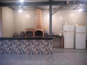 a kitchen with a brick oven and two refrigerators at espaço 16 in Maricá