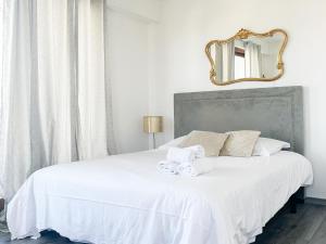 a bedroom with a white bed with a mirror at Mont Royal balcon et piscine in Annecy