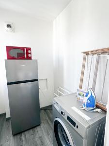 a kitchen with a refrigerator and a washing machine at Mont Royal balcon et piscine in Annecy