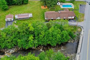 an aerial view of a house and a yard with trees at Riverbank Motel and Cabins Managed by Vacasa in Lincoln