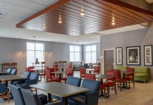 uma sala de jantar com mesas, cadeiras e janelas em Holiday Inn Express - Minneapolis West - Plymouth, an IHG Hotel em Plymouth