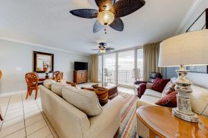 a living room with a couch and a ceiling fan at Emerald Beach Resort II in Panama City Beach