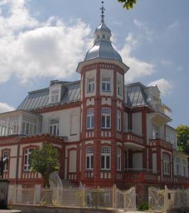 duży budynek z czerwonej cegły z wieżą w obiekcie Villa Stella Maris w mieście Międzyzdroje