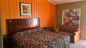 sypialnia z łóżkiem i krzesłem w obiekcie Budget Inn motel Greenville tx w mieście Greenville