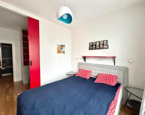 a bedroom with a blue bed with red and white pillows at Project Comfort Leszczyńska 4/33 Warszawa in Warsaw