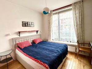 a bedroom with a bed with red pillows and a window at Project Comfort Leszczyńska 4/33 Warszawa in Warsaw