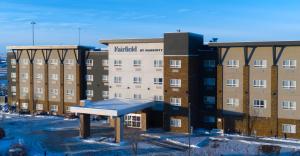 Fairfield Inn & Suites by Marriott Airdrie في إيرداري: مبنى امامه مقعد