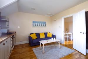 ein Wohnzimmer mit einem blauen Sofa und einem Tisch in der Unterkunft Guildford Station with Parking in Stoughton + 14 Fotos