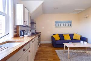 a kitchen with a blue couch and a table at Guildford Station with Parking in Stoughton