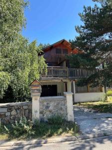 a house with a stone wall in front of it at Aux trois marmottes - Chalet au pied des pistes in Formiguères