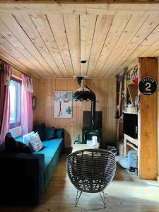 un soggiorno con un divano blu e una sedia di Aux trois marmottes - Chalet au pied des pistes a Formiguères