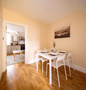 a dining room with a white table and chairs at Guildford Station with Parking in Stoughton