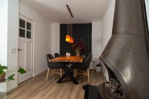 a dining room with a table and a fireplace at Sfeervol verblijf nabij centrum Almelo in Almelo
