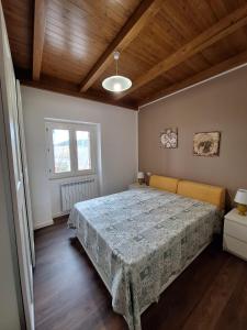1 dormitorio con cama y techo de madera en Casa Vacanze Pianoneve, en Case dʼAmico