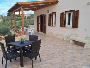 a patio with a table and chairs in front of a house at Case Vacanza Pianoneve in Buseto Palizzolo