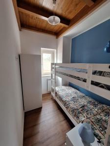 1 dormitorio con 2 literas y pared azul en Casa Vacanze Pianoneve, en Case dʼAmico